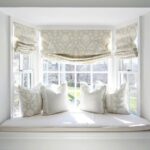 Cozy up a bay window with pretty curtains an upholstered seat .