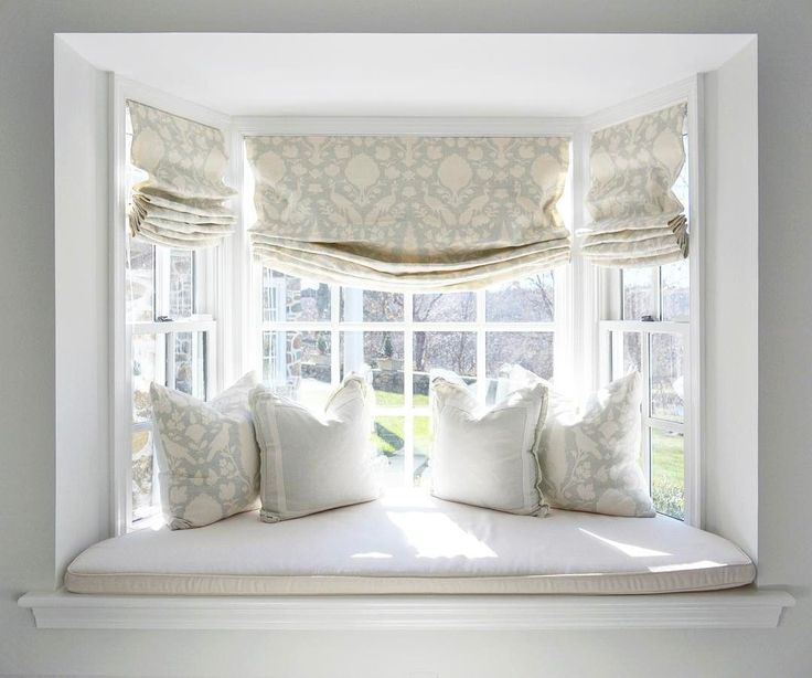 Cozy up a bay window with pretty curtains an upholstered seat .