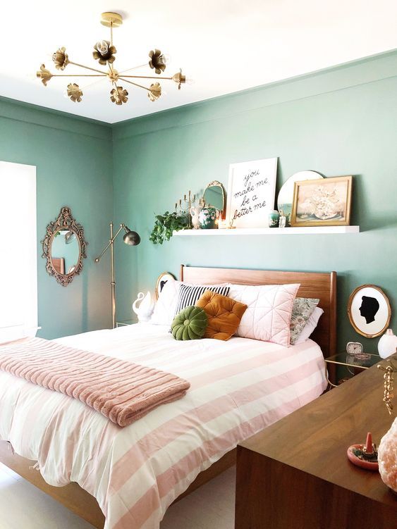 a welcoming bedroom with green walls, wooden furniture, a ledge as .