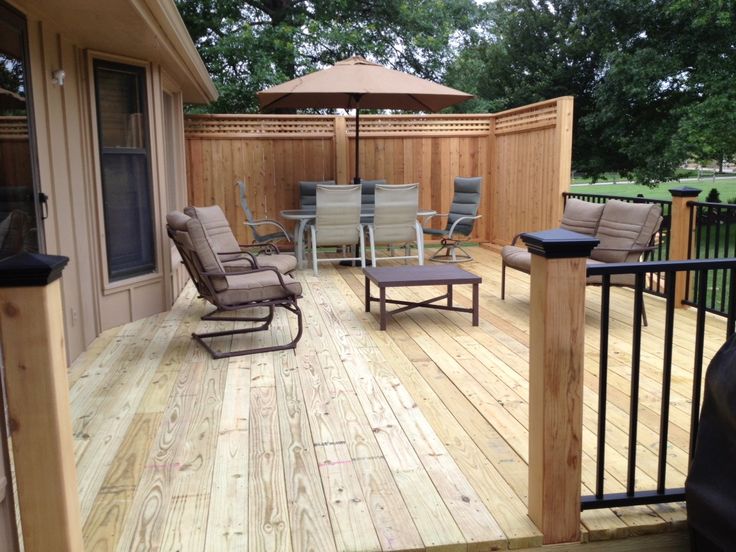 Pressure treated decking with cedar posts and privacy panels .