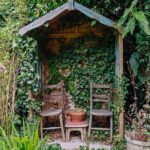 Small garden shelter with two chairs in a rural garden by Paul .