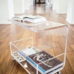 an acrylic coffee table on casters with magazine storage and sheer .