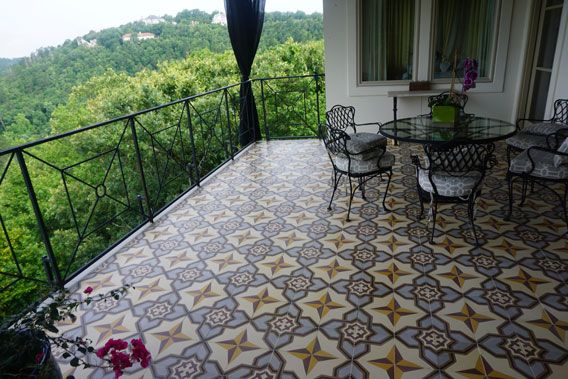 Deck surrounded by woods uses cement tiles to create a harmonious .